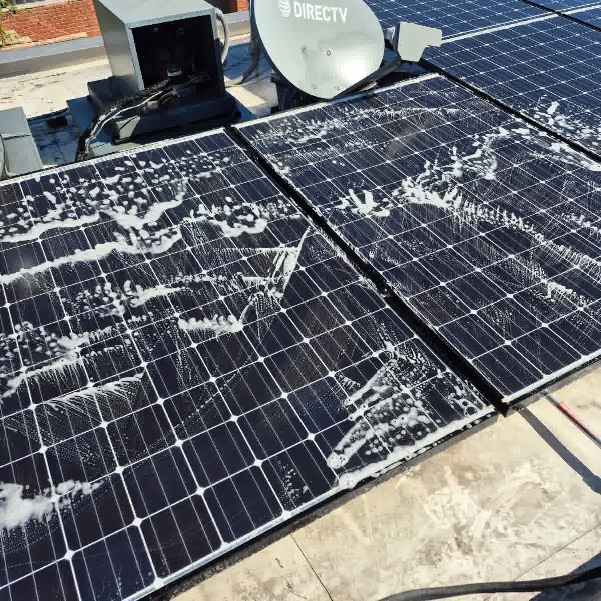Technician cleaning roof solar panels